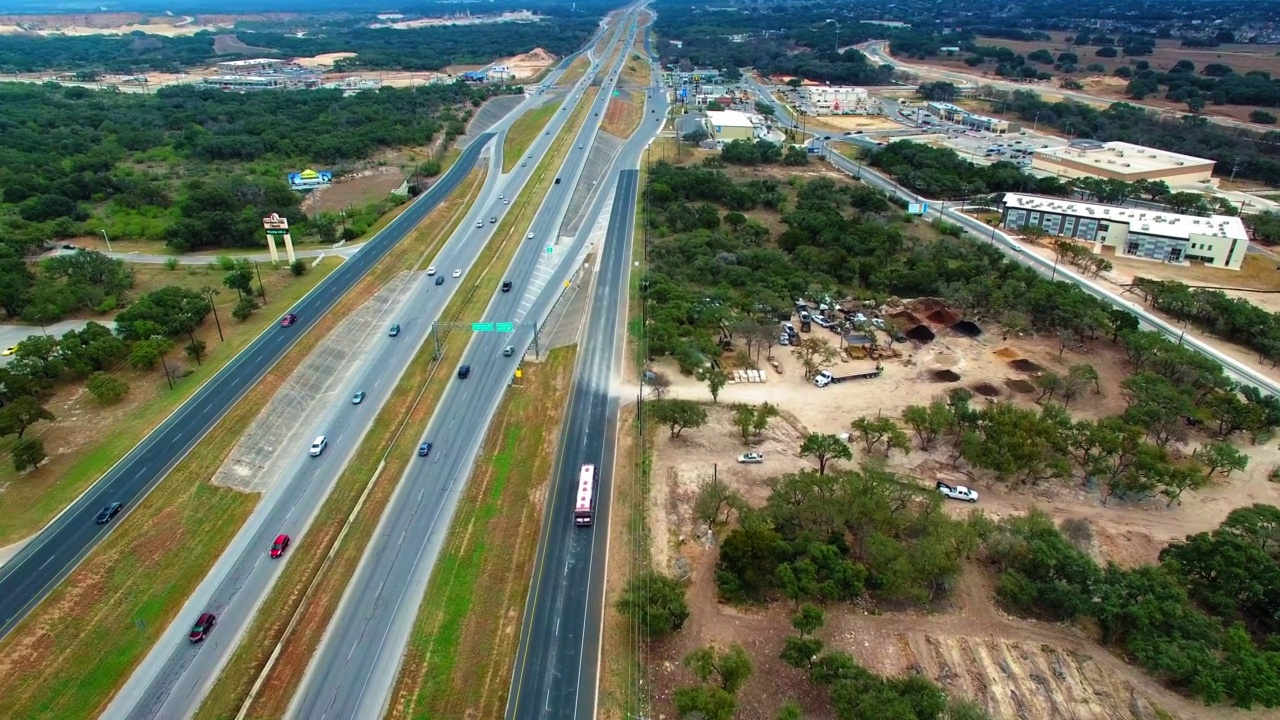 空中向前倾斜向下拍摄的长途汽车和汽车在道路上移动在晴朗的天空-圣安东尼奥，德克萨斯州视频素材