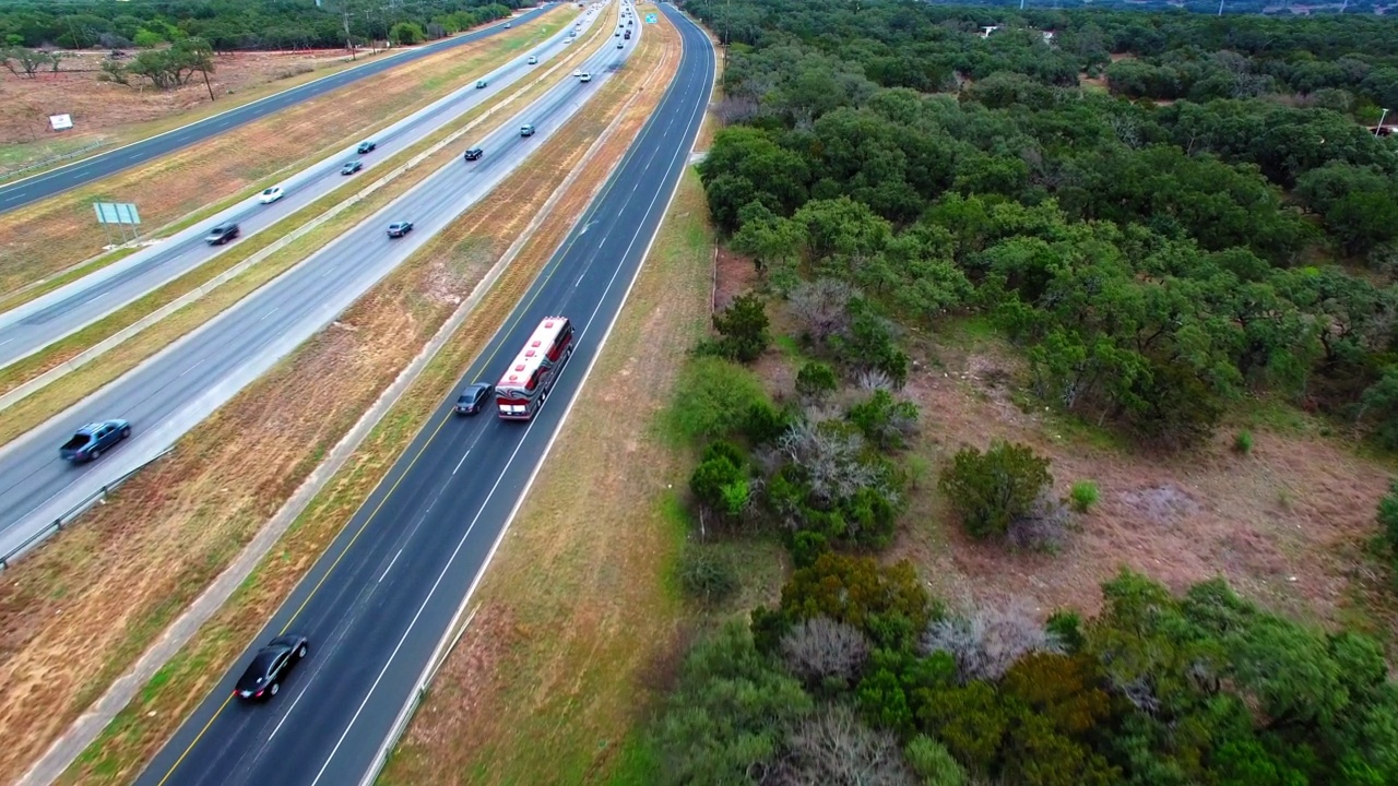 空中向前拍摄的现代公共汽车和汽车在道路上移动的城市工厂-圣安东尼奥，德克萨斯州视频素材