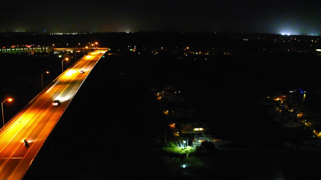 夜间路灯照亮的城市中高速公路上行驶的车辆的空中封锁视图——佛罗里达州的代托纳海滩视频素材