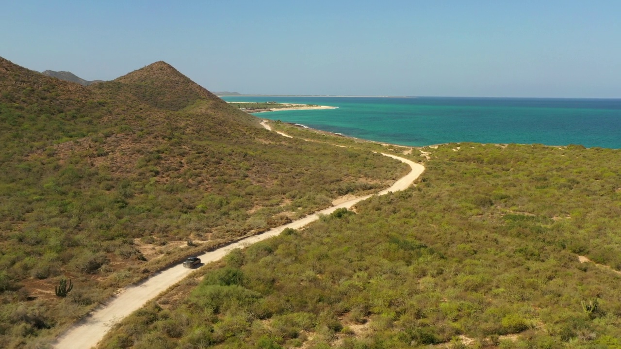 航拍的皮卡移动在道路上的海滩，无人机飞行在自然景观-巴哈加利福尼亚州，墨西哥视频素材