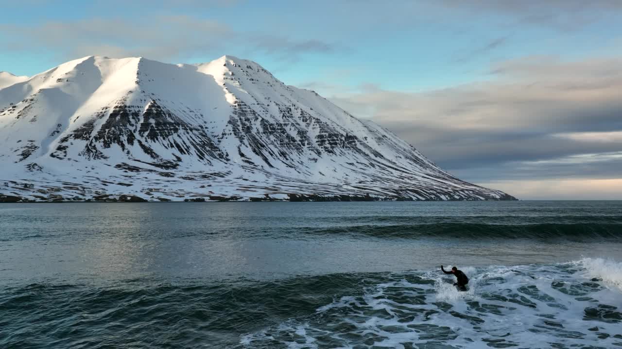 慢动作向后拍摄的人在冒险度假期间在波浪Jokulsarlon泻湖冲浪-冰岛Vatnajokull国家公园视频素材