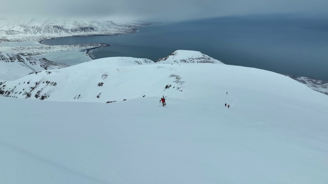 空中向前拍摄的人们在度假期间拄着滑雪杖在海边的冰川山上行走的照片——冰岛的瓦特纳冰川国家公园视频素材