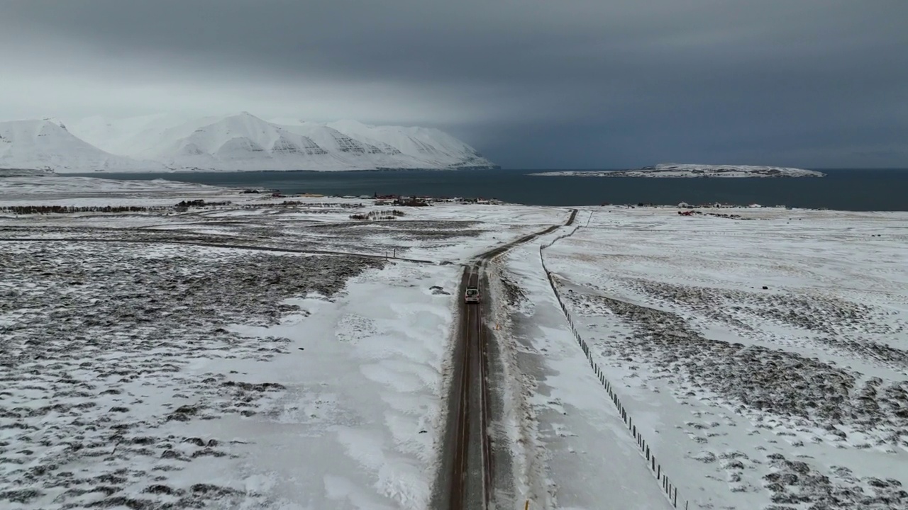 航拍的汽车住宅移动在道路上向大海，无人机向前飞越雪原-瓦特纳冰盖国家公园，冰岛视频素材