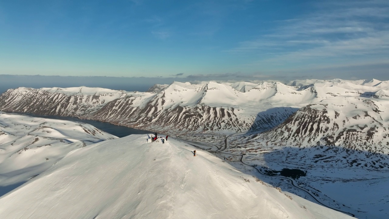 空中拍摄的冒险的游客在雪山山顶，无人机在阳光明媚的日子飞行-冰岛瓦特纳冰川国家公园视频素材