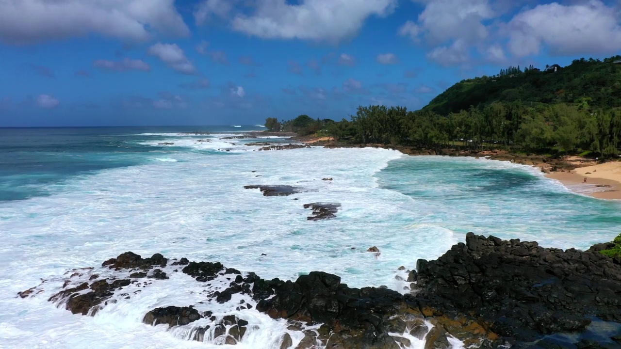 空中生长的树木在海滩和山上，无人机在云下的海浪上向前飞行-怀基基，夏威夷视频素材