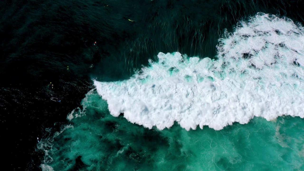 度假期间，游客在碧绿的海浪上冲浪的空中倾斜镜头——夏威夷的威基基视频素材