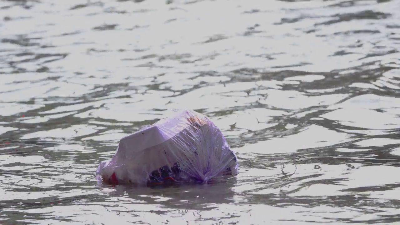 垃圾漂浮在被洪水淹没的道路上。视频素材