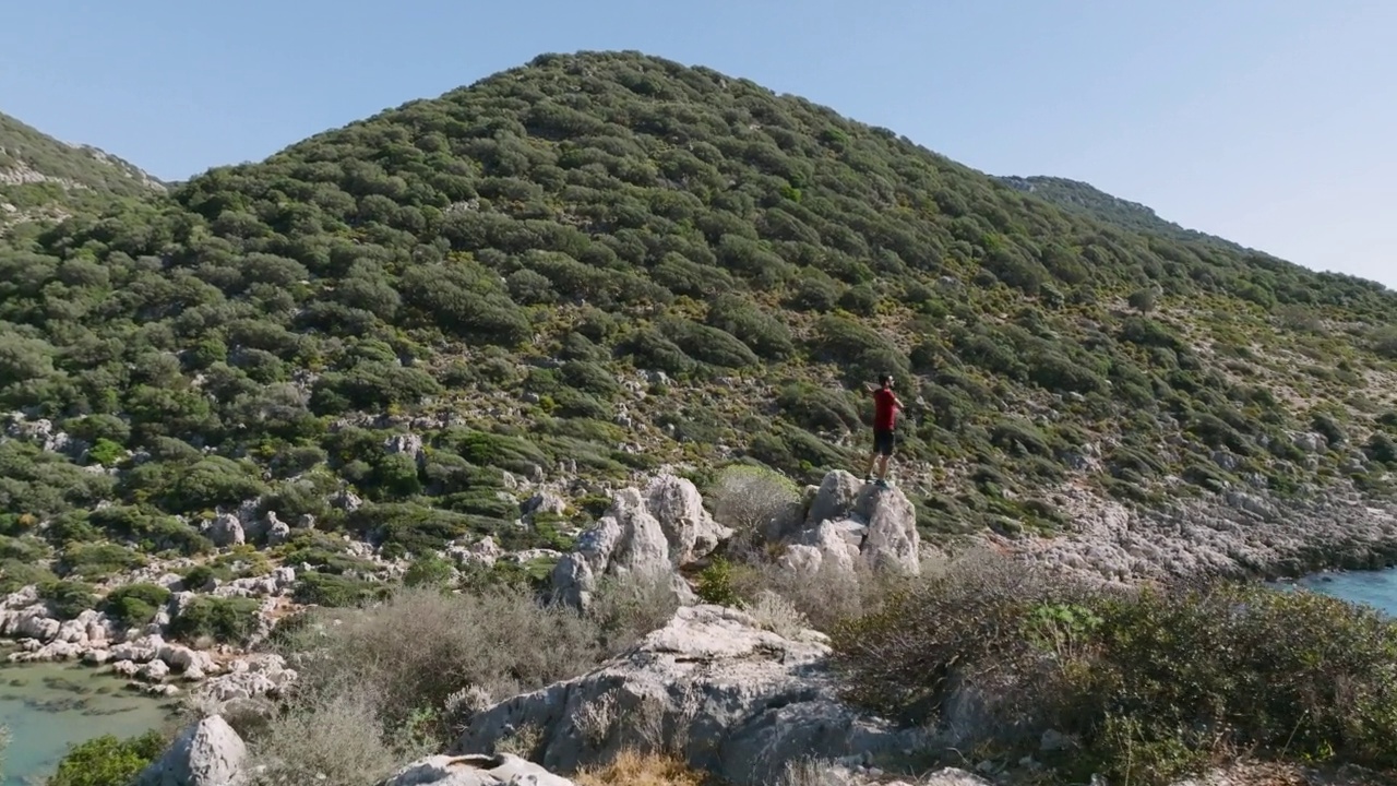 男人站在美丽的海景上，年轻人在山顶上欣赏风景，男人在高处看风景，感受自由，自由的姿态，自由的人，摄影师看风景视频素材