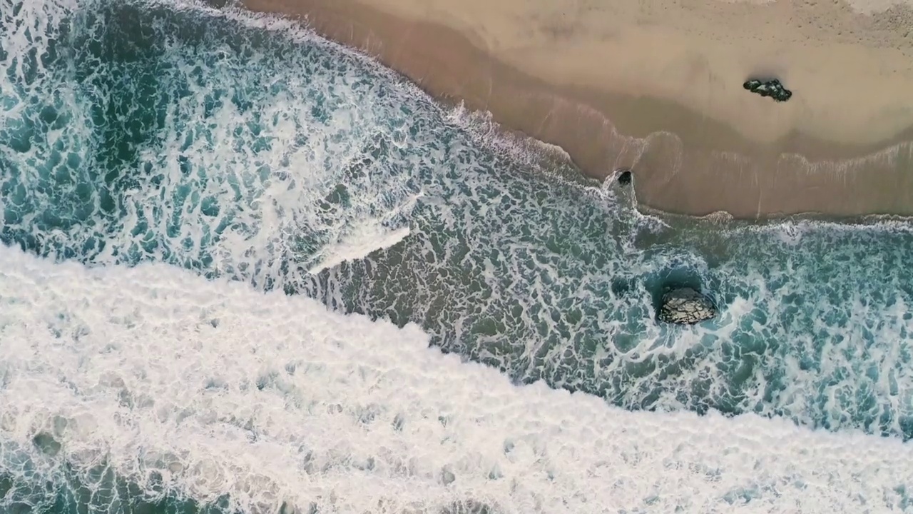 航拍的绿色海浪涌向加州大苏尔的海岸视频素材