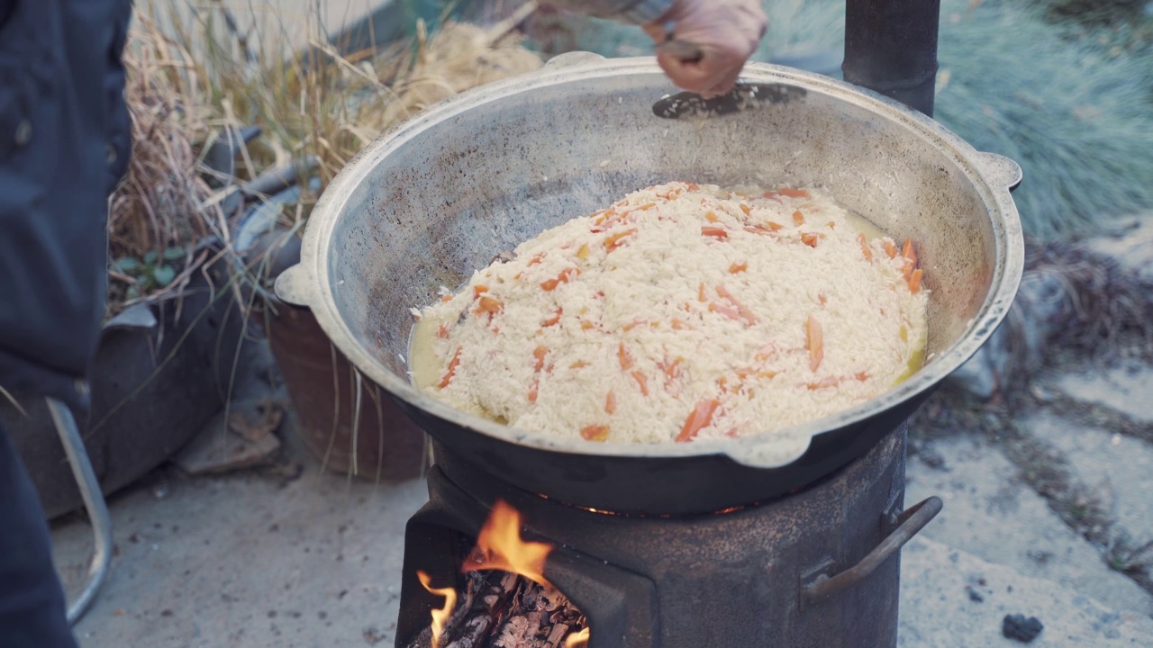 用漏勺在锅里拌肉饭。视频素材