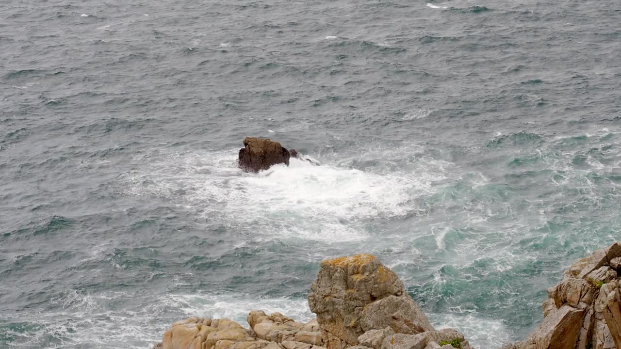 在法国布列塔尼西海岸，海浪拍打着一块岩石视频下载