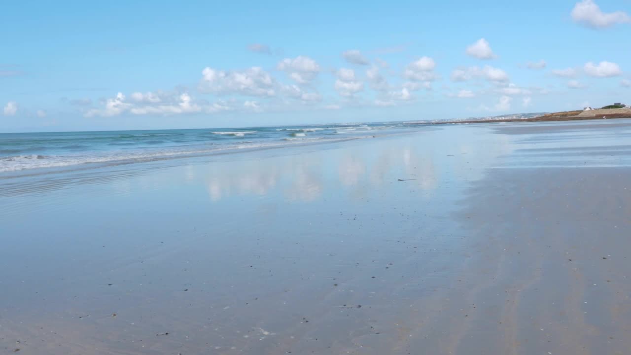 在法国的布列塔尼海岸，海浪嬉戏和平坦的沙滩视频下载