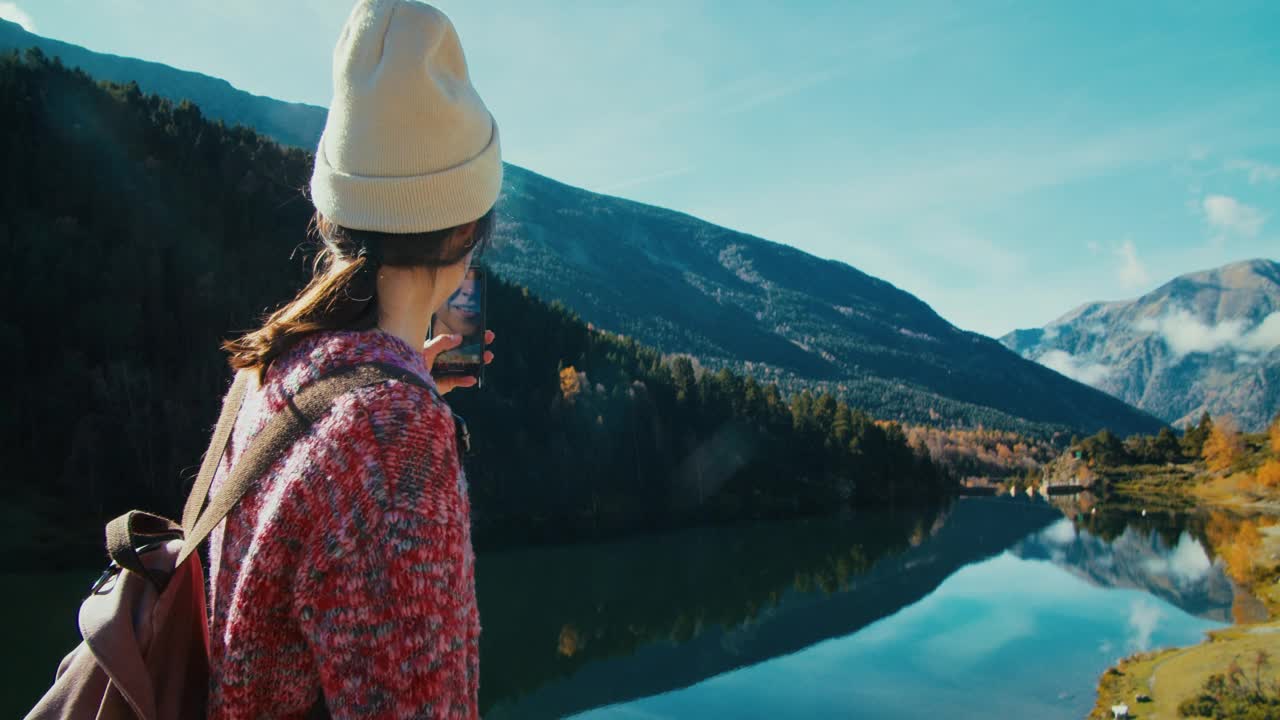 度假旅行中，女游客在山河边用智能手机散步视频素材