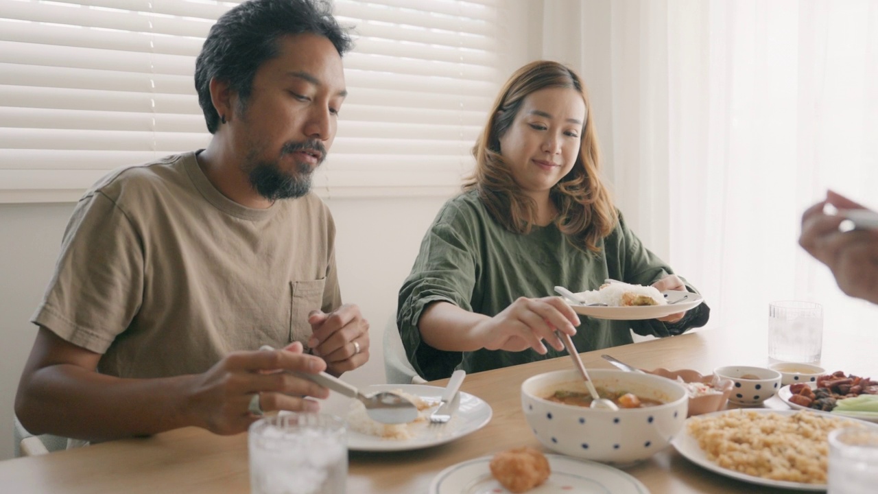 亚洲情侣和朋友在家里享受晚餐庆祝派对。视频素材