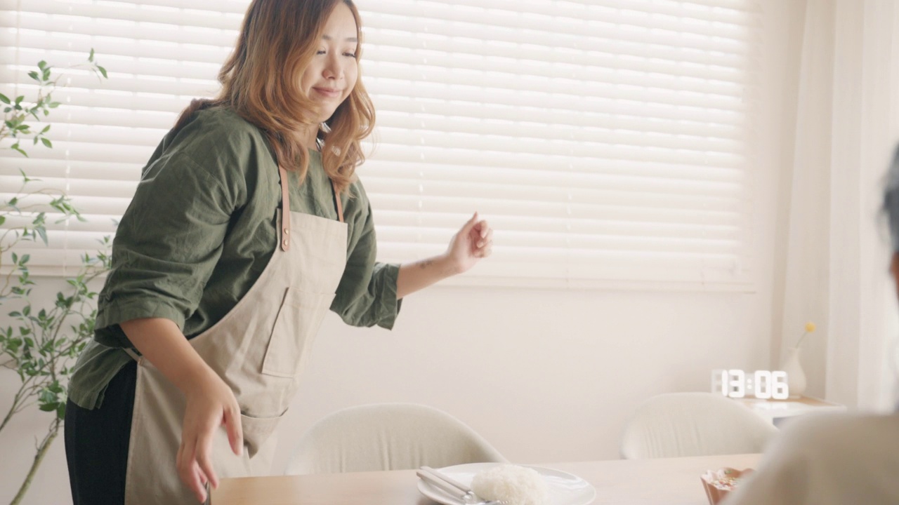 年轻的亚洲男女把美味的食物放在桌子上。视频素材