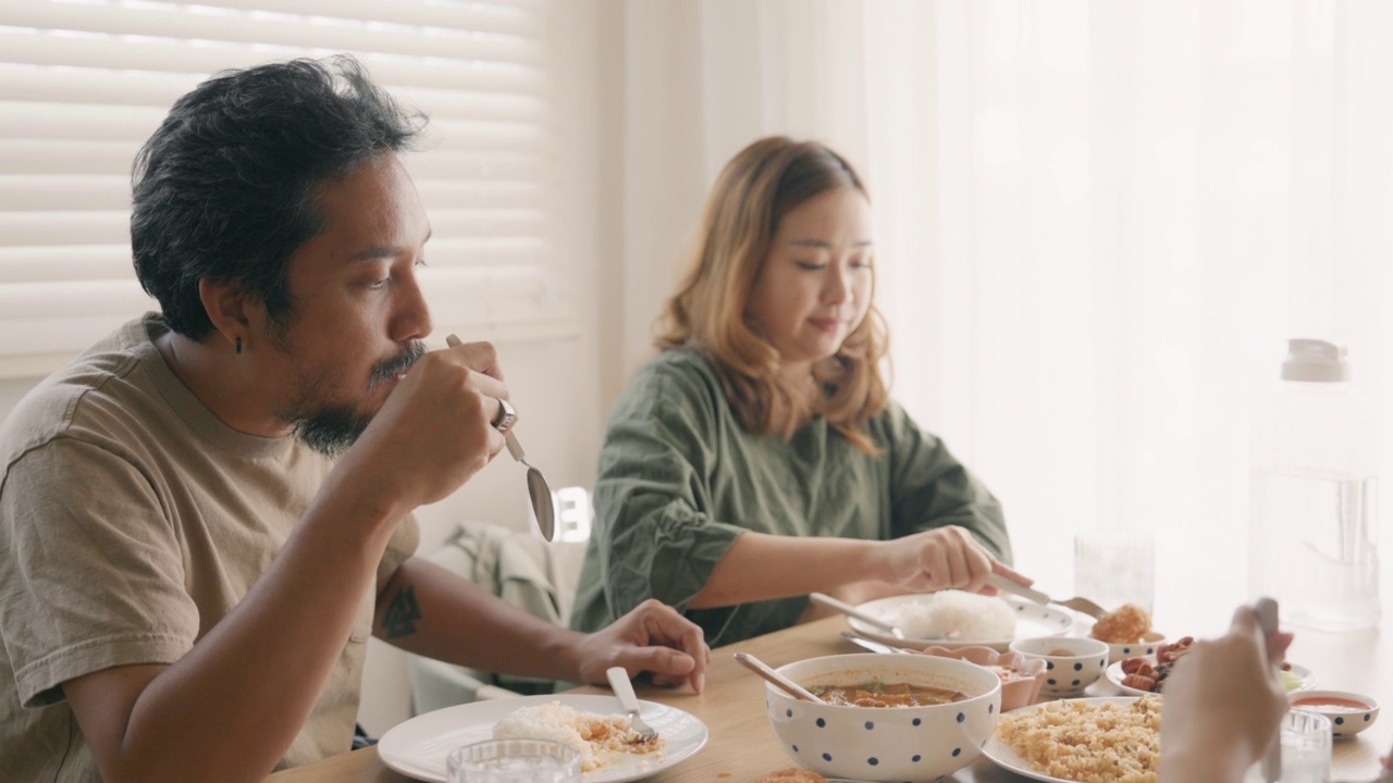 一对年轻的亚洲夫妇和朋友一起吃午餐。视频素材