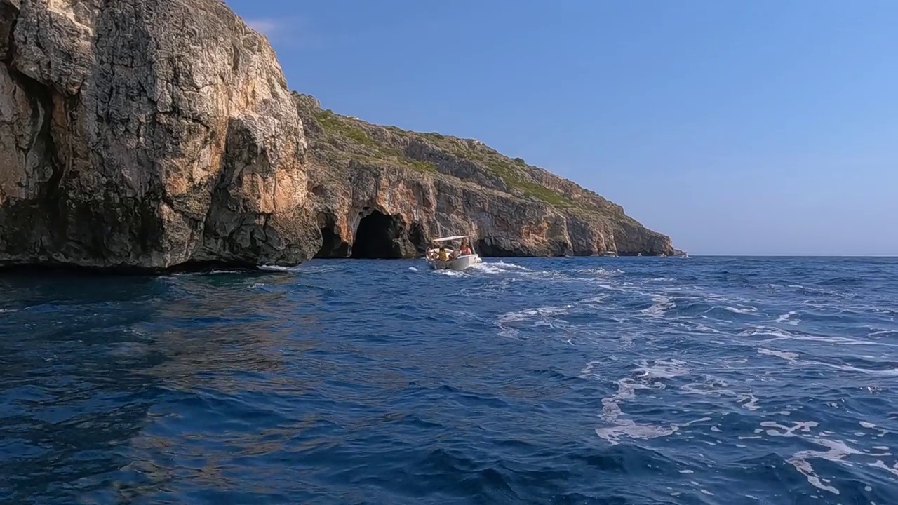 汽艇沿着蓬塔梅利索海岸线航行，那里是爱奥尼亚海和亚得里亚海的交汇处。意大利的阿普利亚地区，慢镜头视频素材