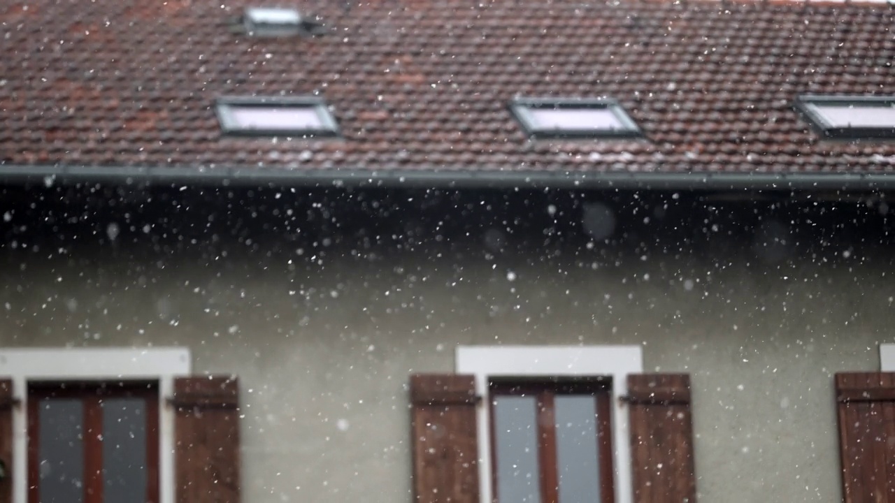 冬天飘落的雪花。建筑的外观与雪花在前景视频素材