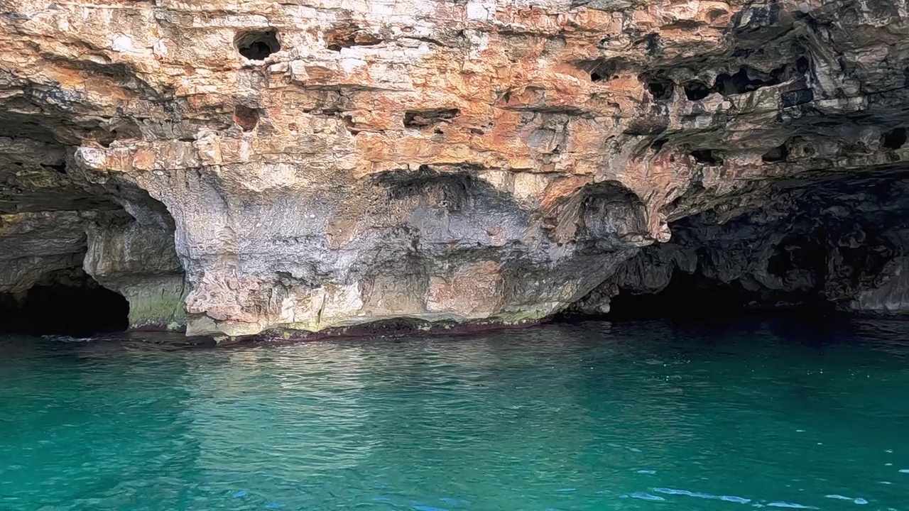 意大利阿普利亚地区萨伦托的美丽Grotta Della Stalla或稳定洞穴。慢动作船的视角视频素材