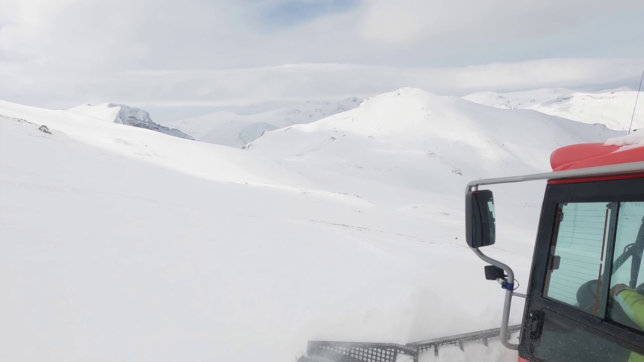 带扫雪机的雪地车准备滑雪坡道，在滑雪场的深雪道上行驶。重型机械运输自由风格的滑雪者在山顶视频素材