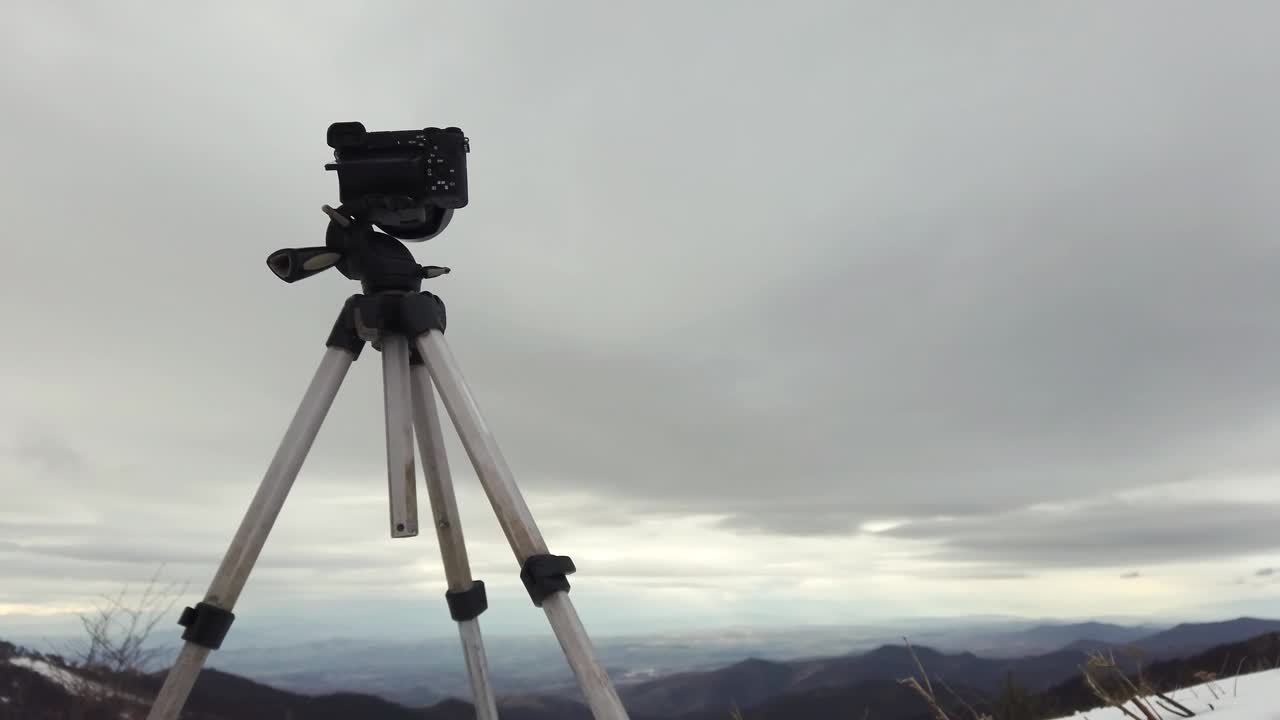 冬季景观，相机在三脚架对焦捕捉雪山和大雨云视频素材