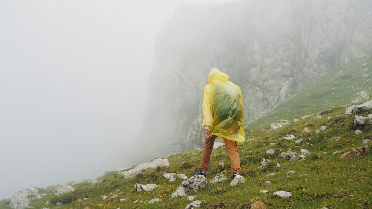 女人在多雨多雾的天气里爬山很困难视频素材