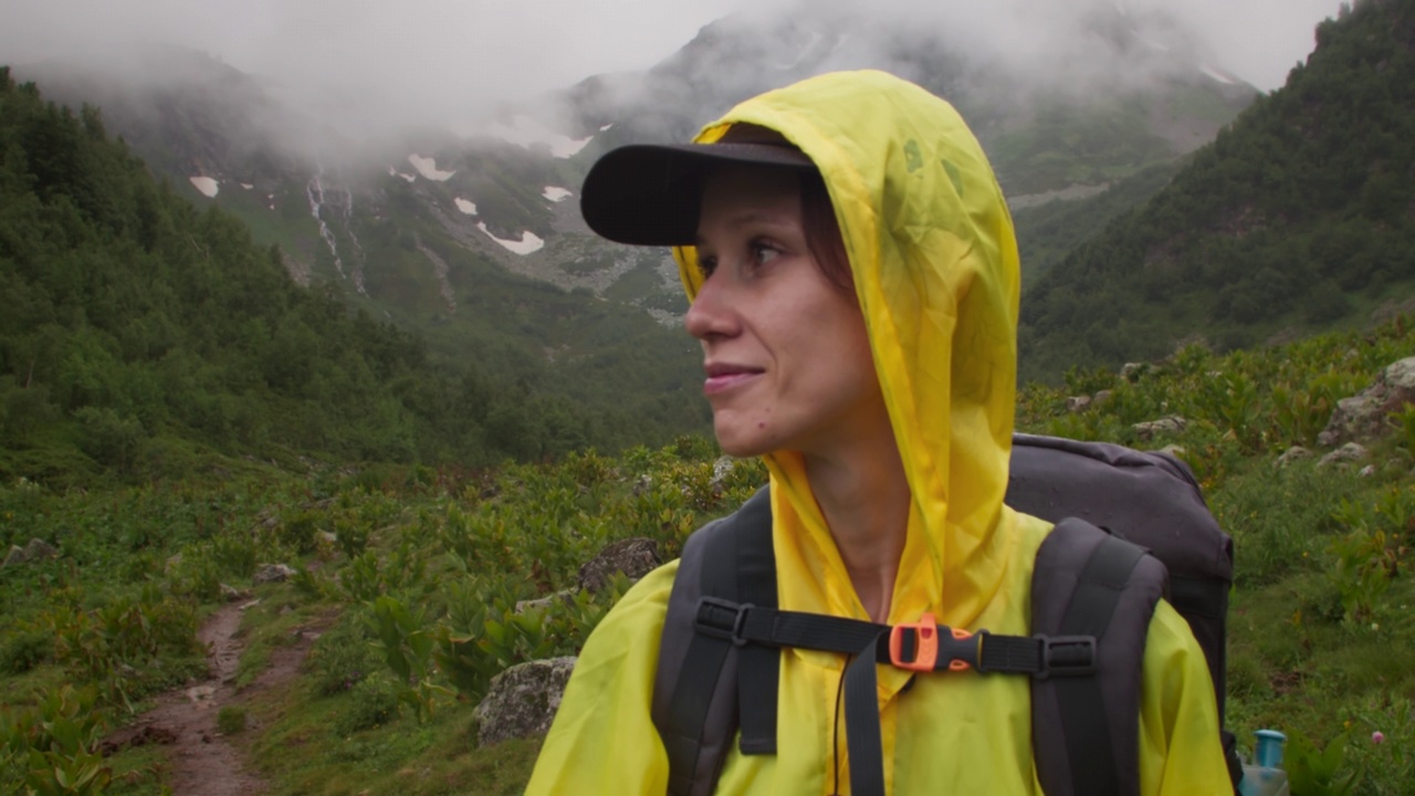 快乐的女子徒步享受平静的雨天在山谷视频素材