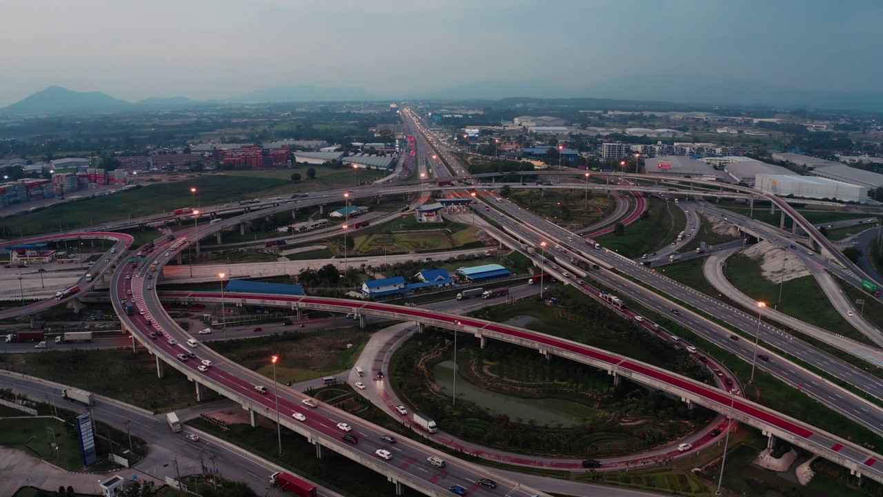 黄昏时高速公路交叉口和移动的交通车辆的航拍俯视图。城市里有多条路。工业城市的运输和货物递送。视频素材