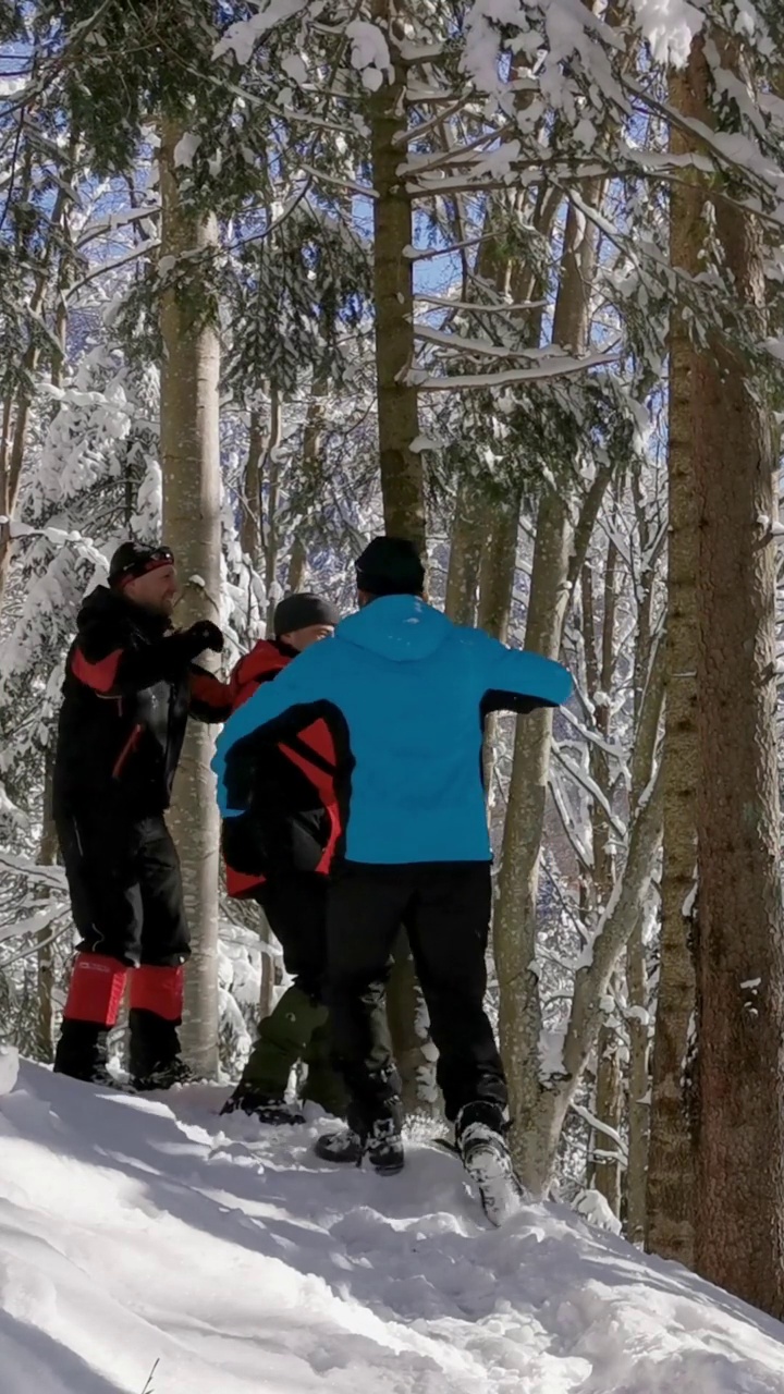 朋友们在冬季徒步旅行中铲雪视频素材