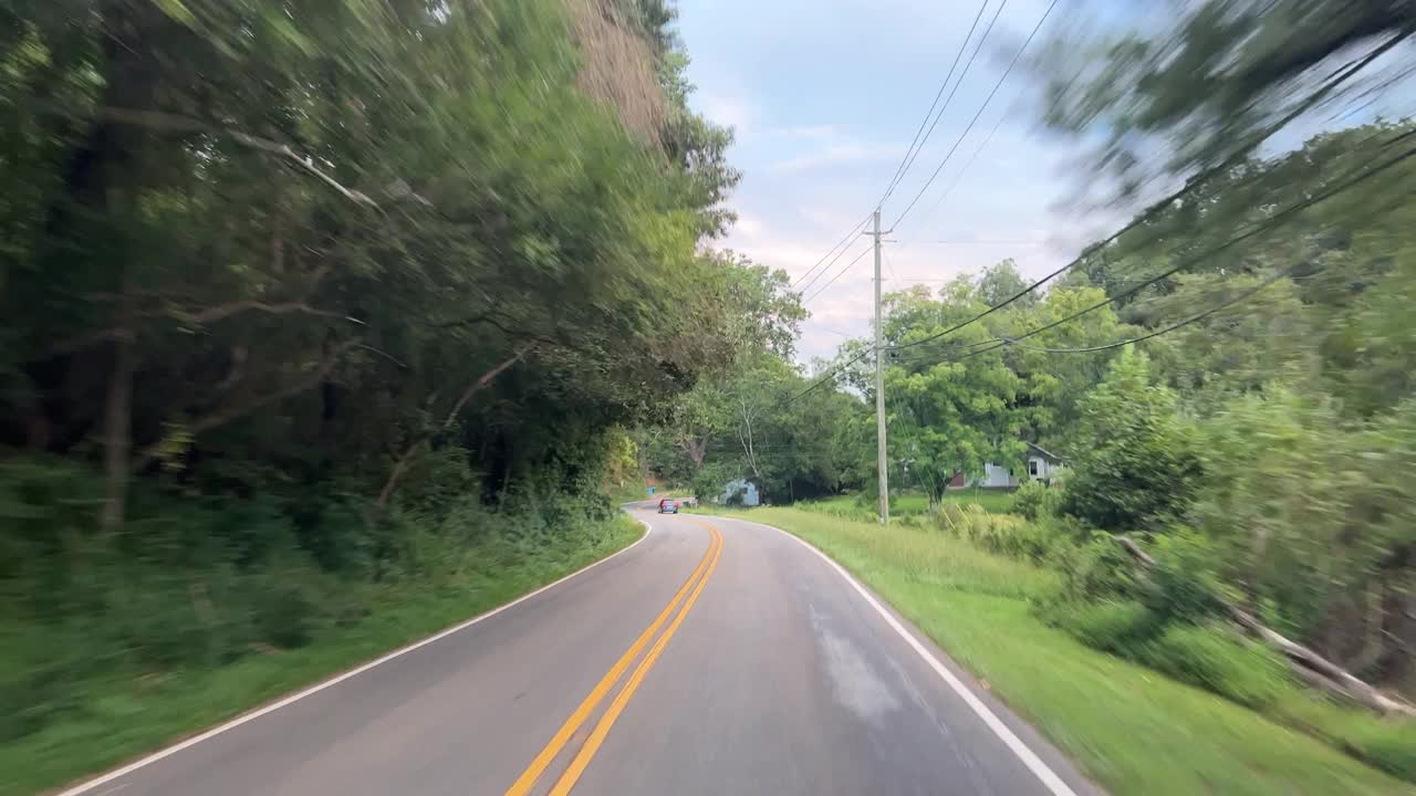 在日落时分的阴天，沿着绿树成荫的夏洛特高速公路行驶，路过北卡罗来纳州费尔维尤的小企业视频素材