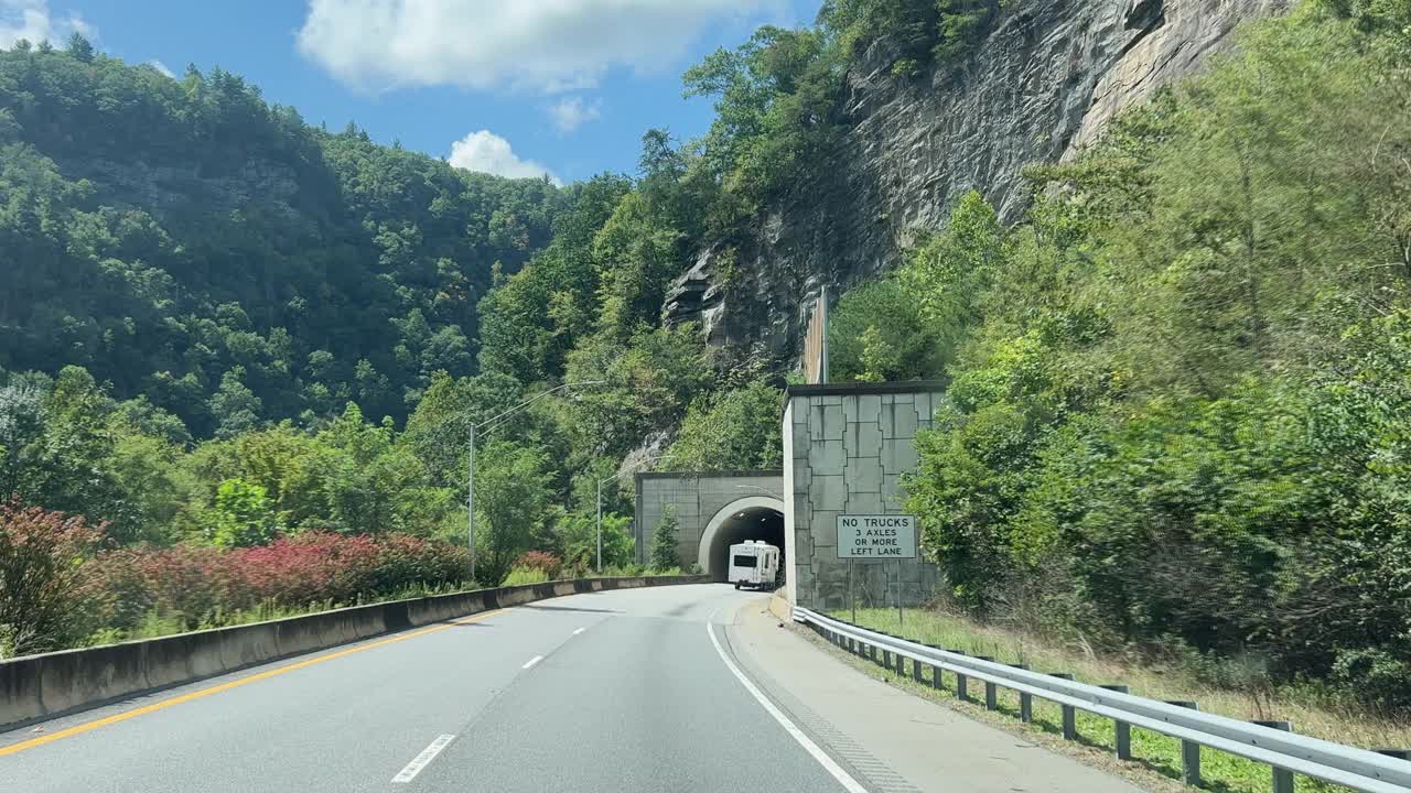 在一个阳光明媚的日子里，开车穿过北卡罗来纳州蓝岭山脉40号州际公路上的隧道视频素材