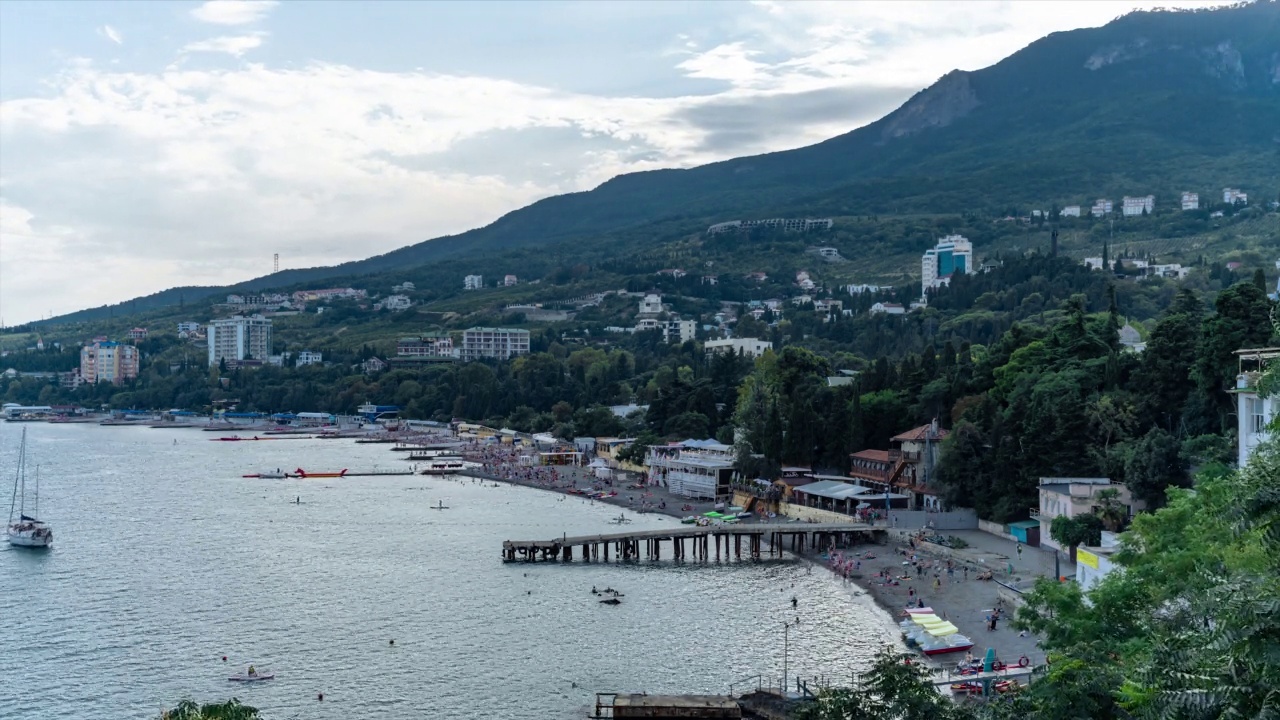 时间推移的公共海滩与度假者，游客，咖啡馆，餐厅，酒店在山上视频下载