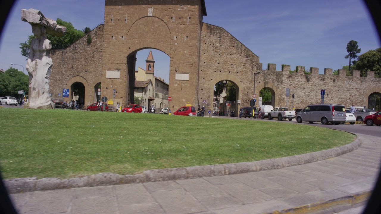 PROCESS PLATE STRAIGHT LEFT OF CAR DRIVING THROUGH PIAZZALE DI PORTA ROMANA TRAFFIC CIRCLE. PISTOLETTOÕS DIETROFRONT STATUE AND PORTA ROMANA GATE VISIBLE. SCOOTERS AND PEDESTRIANS VISIBLE视频素材