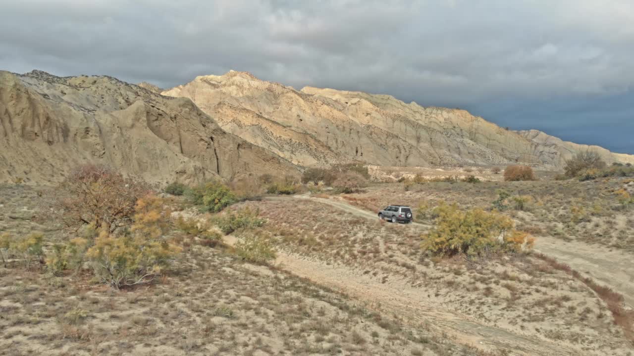 无人机从上到下鸟瞰4x4车在砾石小道上行驶视频素材