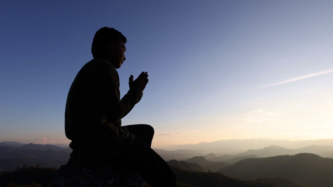 秋日日出背景上少年向上帝祈祷的剪影，宗教观念。视频素材