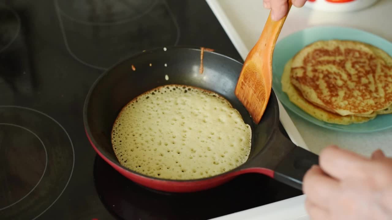 用煎锅近距离选择性聚焦煎自制煎饼的过程。Maslenitsa，春节的概念。俄罗斯传统食物。煎饼。美味的早餐视频素材