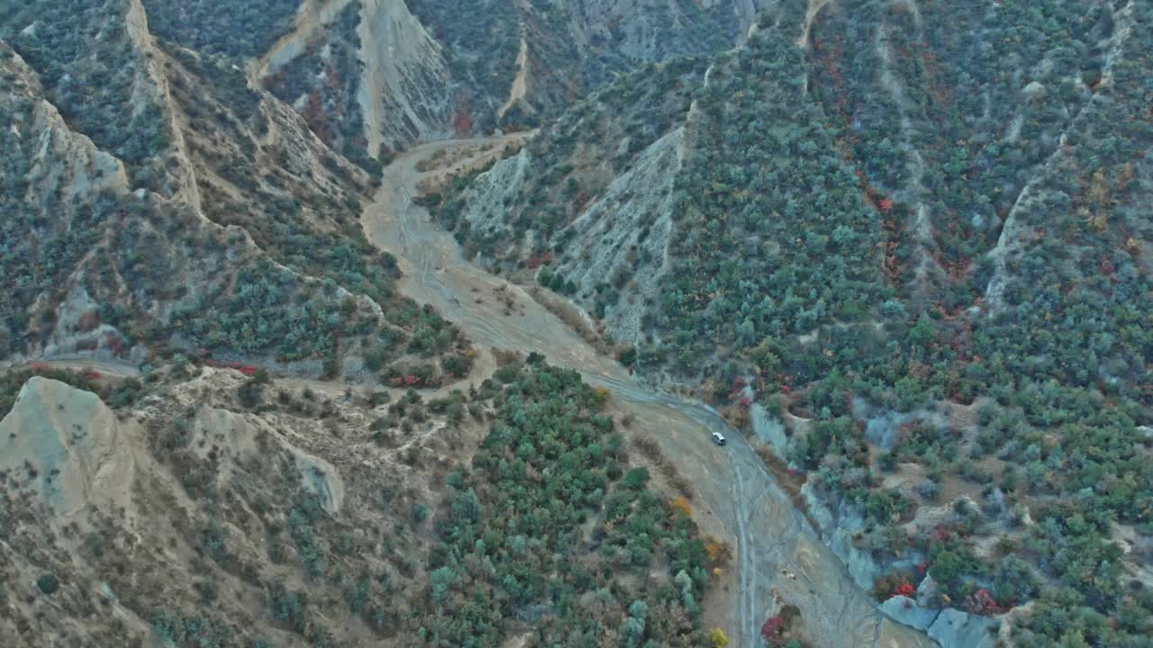 高空无人机拍摄的四轮驱动汽车行驶在格鲁吉亚高加索山脉视频素材