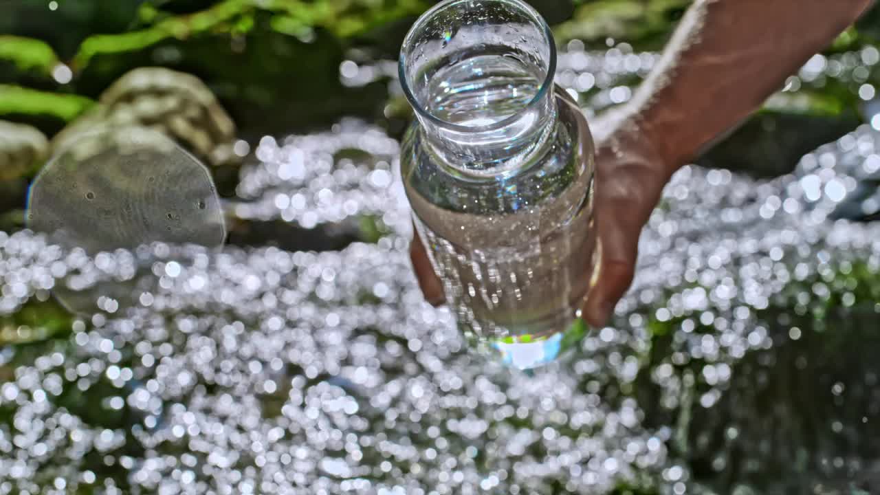 把新鲜的矿泉水倒进小溪视频素材