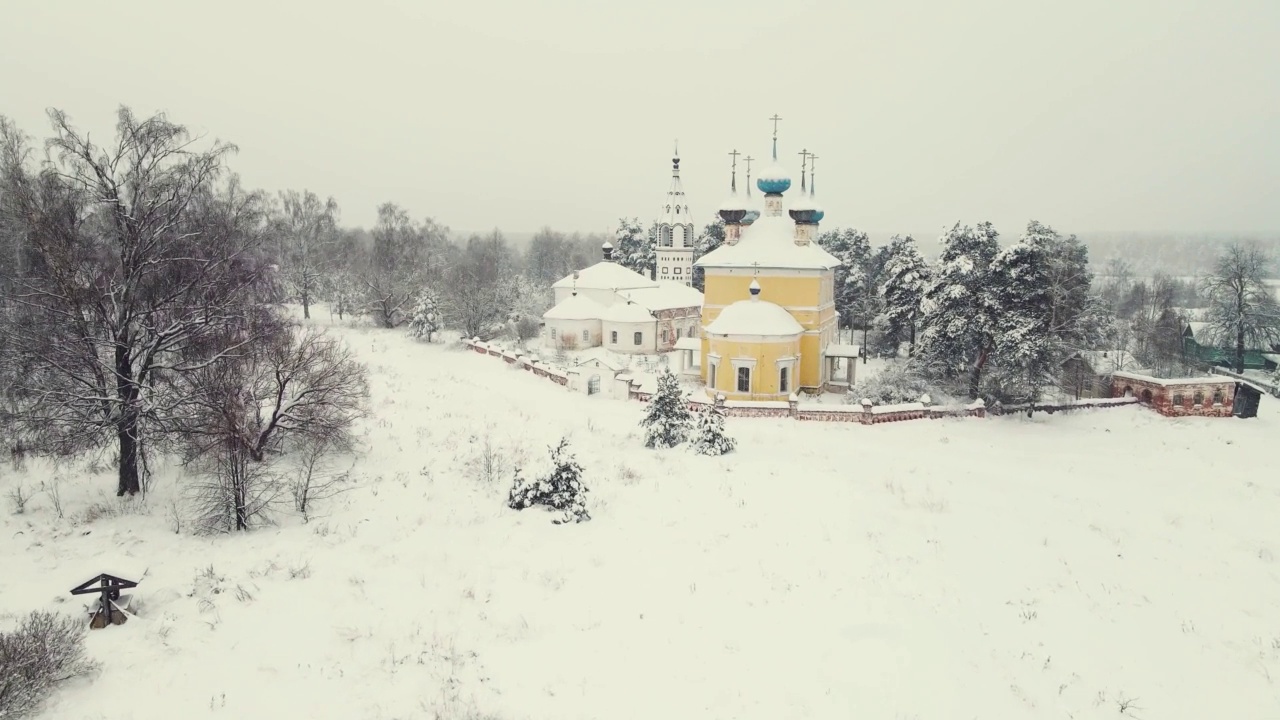 美丽的鸟瞰图，一个白雪覆盖的村庄在冬天有一个教堂。视频素材