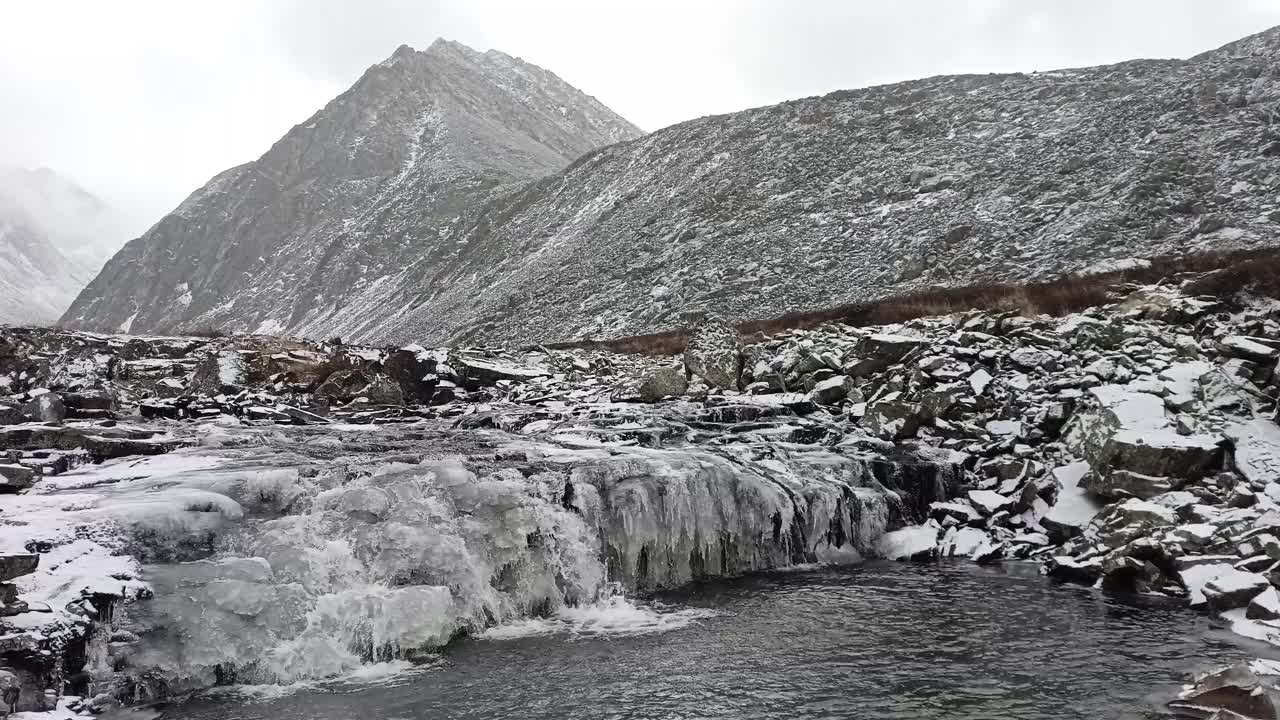 一个小海湾和被高山环绕的部分冻结的瀑布。视频素材