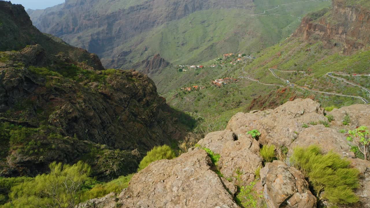 山岭绝壁，险峻峭壁。著名的旅游目的地。西班牙加那利岛特内里费岛。壮观的鸟瞰图，小舒适的定居点村庄在马斯卡峡谷的山边。视频素材