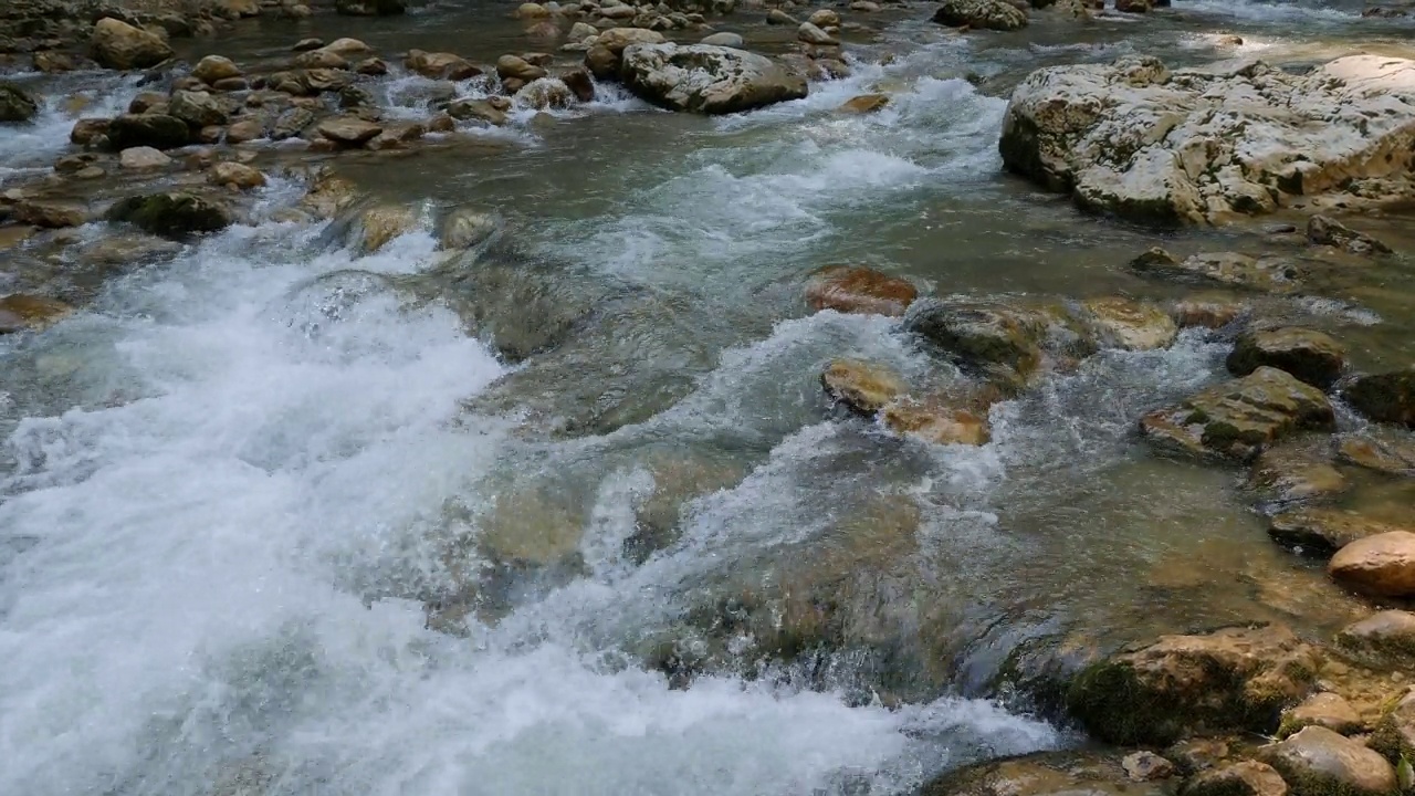 快喧闹的山河在夏天的峡谷里，河水湍急。视频素材