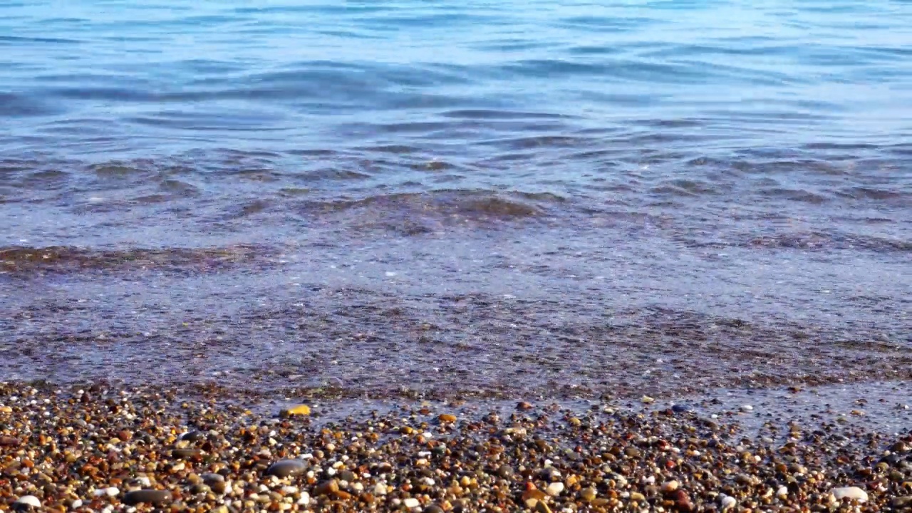 滑行的海浪，特写。海岸上有大片的沙子。视频编辑的美丽背景。视频素材