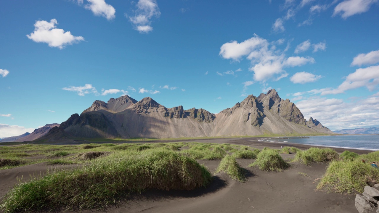 冰岛Stokksnes半岛，Vestrahorn山的风景和阳光明媚的黑色沙滩上的草丛视频素材