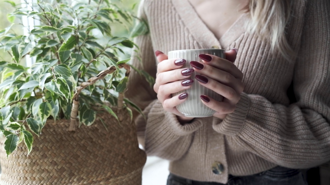 美丽的手，一个年轻的女人与深红色的指甲美甲。视频素材