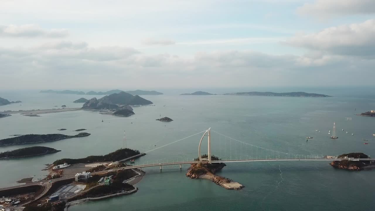 韩国全北群山岛(群山市)仙游岛(senonyudo Island)、文约岛(Munyeodo Island)和群山山桥(gogunsandigyo Bridge)周围的村庄和海面上的日落视频素材