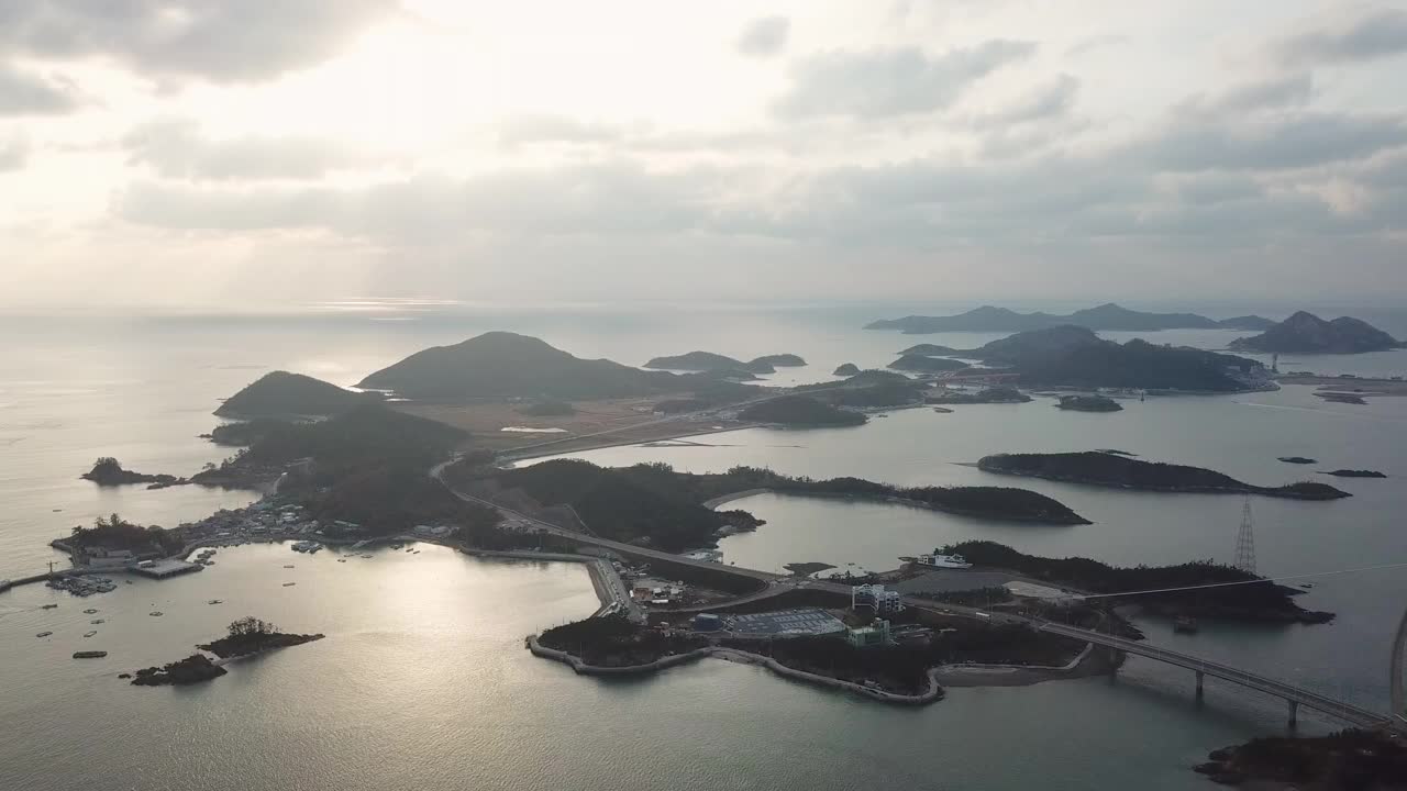 韩国全北群山岛/群山市的文余岛、善游岛、长刺岛、大长岛、高郡山桥和善游桥周围的村庄和海面上的日落视频素材