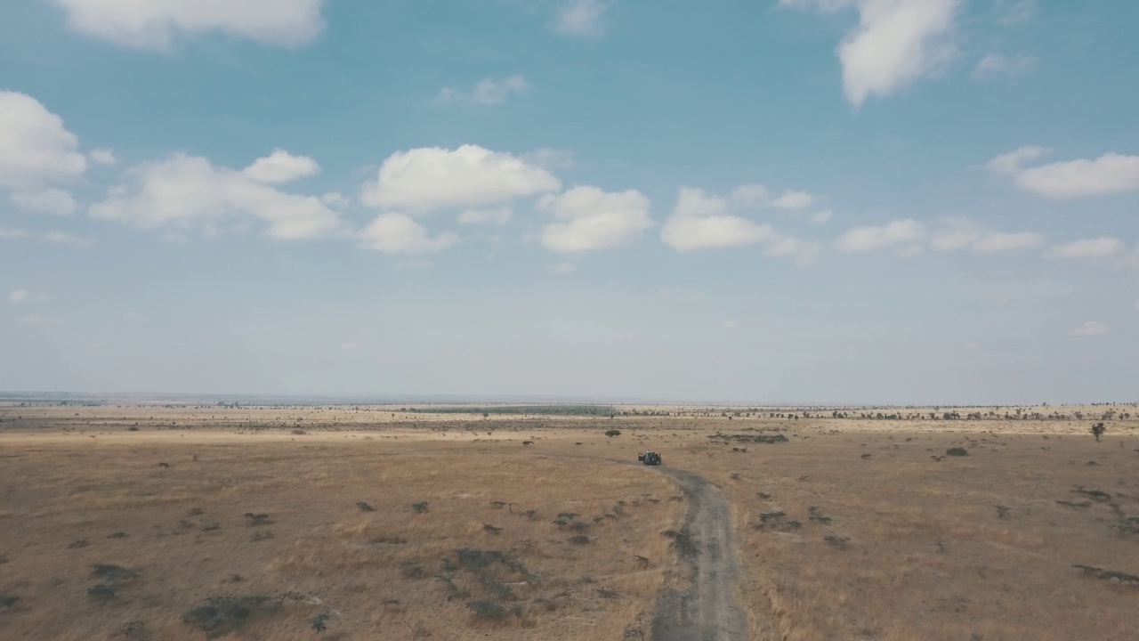 无人机拍摄的一片荒无人烟的土地，几乎没有绿色植物，路上有一辆车视频素材