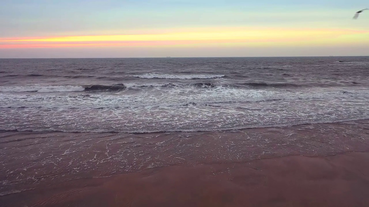 落日时分，鸟瞰美丽的大海，海浪拍打着沙滩视频素材