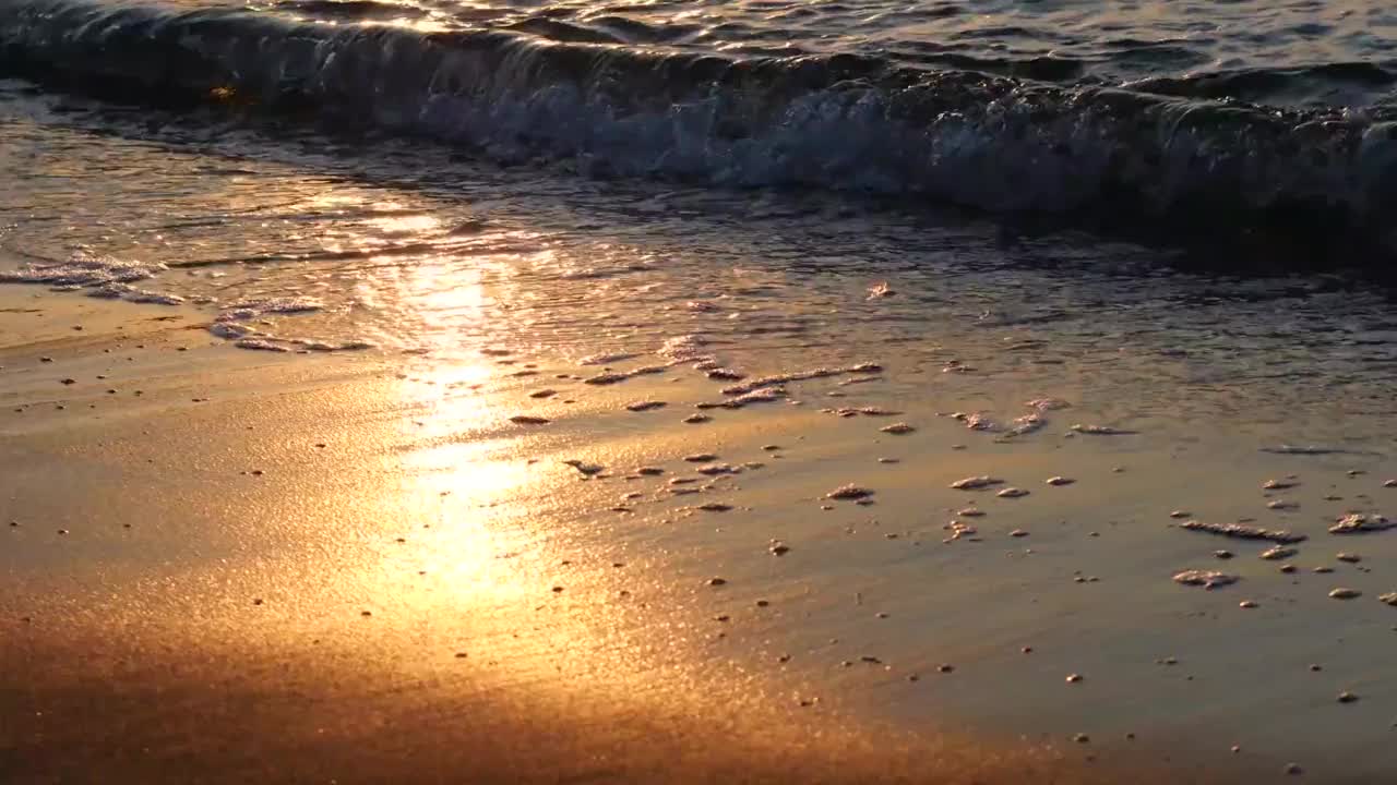 日落时沙滩上海浪的特写视频素材